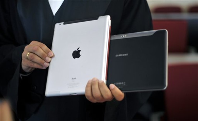 A lawyer holds an Apple iPad and a Samsung Tablet-PC at a court in Duesseldorf, Germany. 